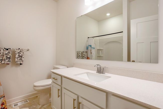 Immaculate full bath with a sleek quartz vanity, updated fixtures, and stylish tile flooring. | Image 28