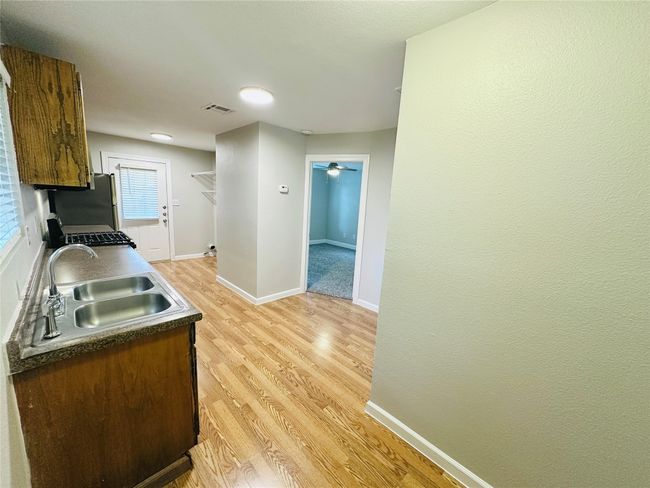 Kitchen with light wood finished floors, stainless steel appliances, and ceiling fan | Image 9