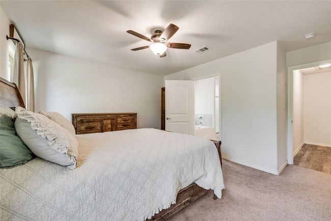 Bedroom featuring carpet, connected bathroom, a ceiling fan, visible vents, and baseboards | Image 21
