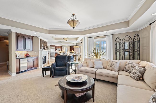 Living area featuring crown molding, recessed lighting, a raised ceiling, and light colored carpet | Image 8