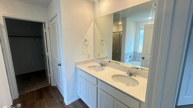Bathroom featuring dark wood-style flooring, a garden tub, double vanity, a walk in closet, and a shower stall | Image 24