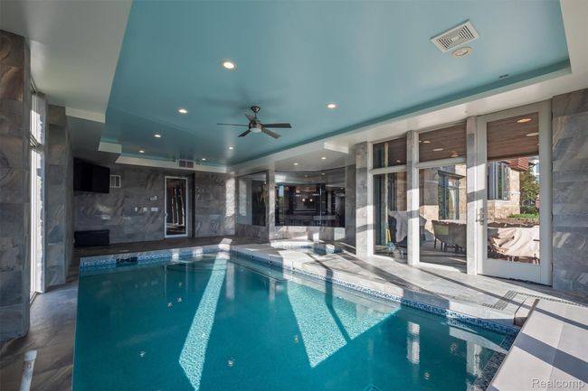 Indoor pool with ceiling fan | Image 31