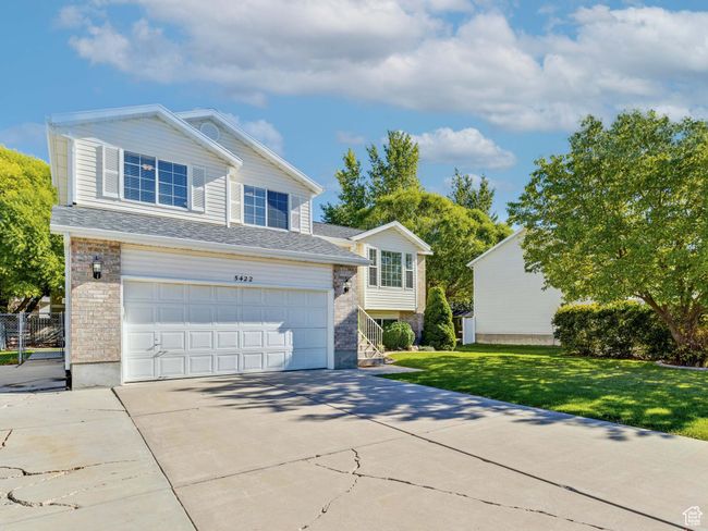 View of front facade featuring brick siding, an attached garage, driveway, and a front yard | Image 18