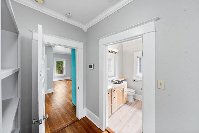 Hallway with crown molding, light wood-style flooring, and baseboards | Image 14