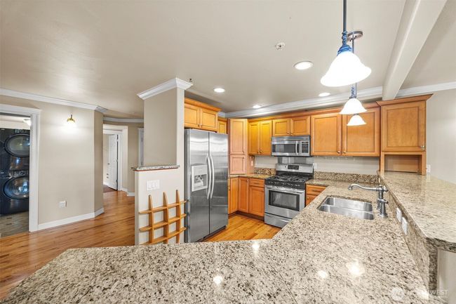Kitchen has plenty of cabinet and counter space. Door furthest on left leads to third bedroom. Door closest is to utility room. | Image 9
