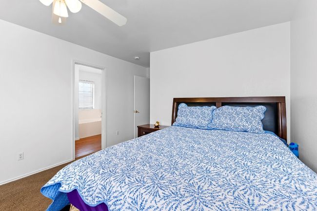 Carpeted bedroom featuring ceiling fan and ensuite bath | Image 29