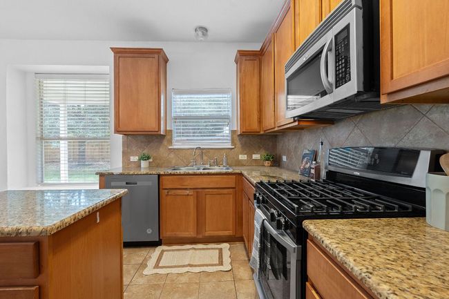 Kitchen featuring appliances with stainless steel finishes, a sink, healthy amount of natural light, and light tile patterned floors | Image 10