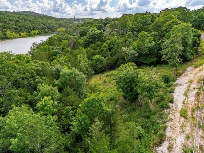 Aerial view of a heavily wooded area and a nearby body of water | Image 17