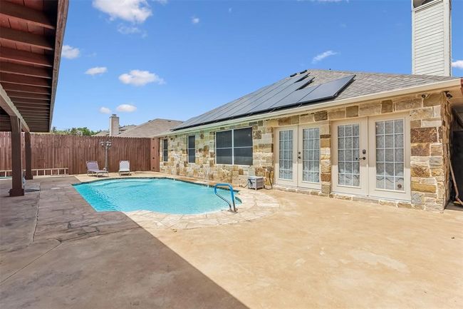 View of swimming pool featuring a fenced backyard, a fenced in pool, french doors, and a patio | Image 20