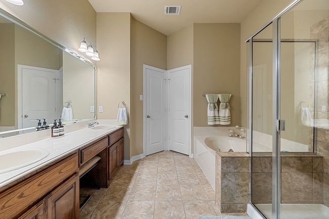 Bathroom featuring double vanity, a garden tub, a stall shower, and a sink | Image 15