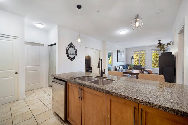 Kitchen with brown cabinets, pendant lighting, stainless steel dishwasher, and a sink | Image 8