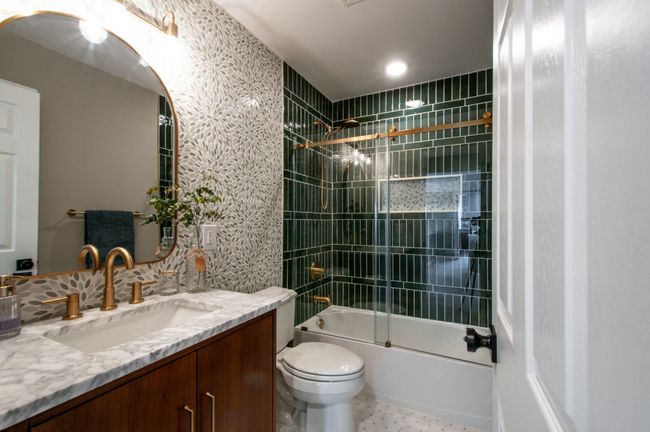 The fully renovated upper level bathroom is a show stopper with gorgeous designer tile, an impressive vanity, a lovely mirror and gorgeous fixtures and lighting! | Image 34