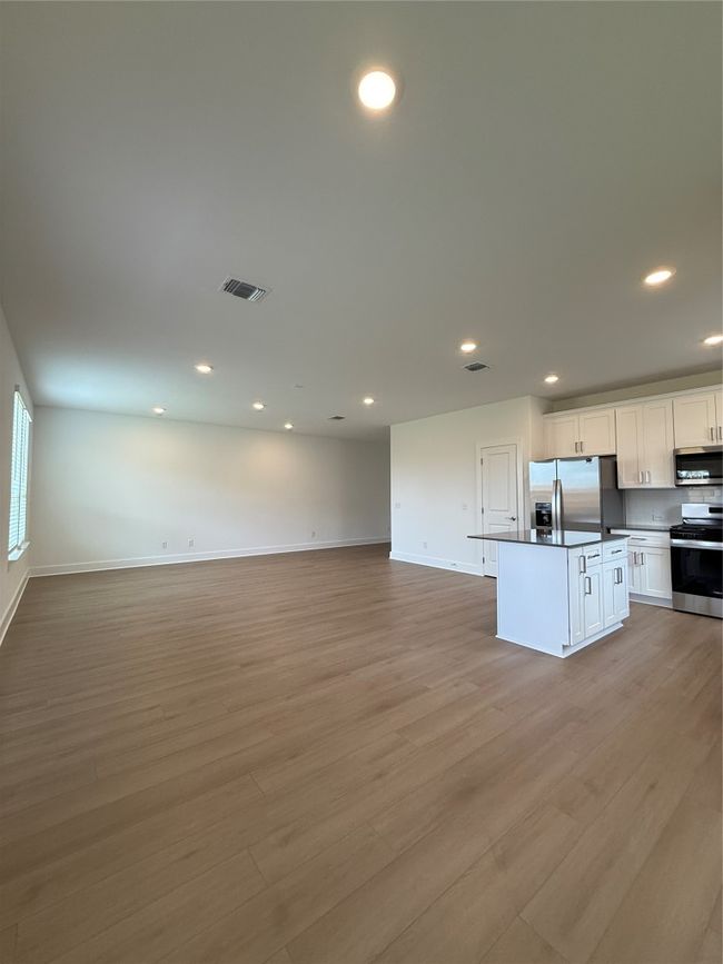 Kitchen featuring stove, open floor plan, refrigerator, light wood finished floors, and baseboards | Image 21