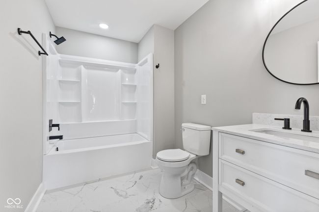 bathroom featuring marble finish floor, shower / bathtub combination, toilet, vanity, and baseboards | Image 28