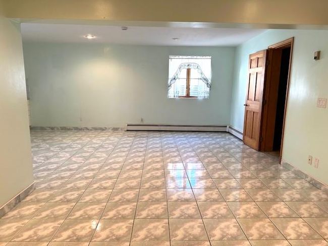 Empty room with baseboard heating and light tile patterned flooring | Image 24