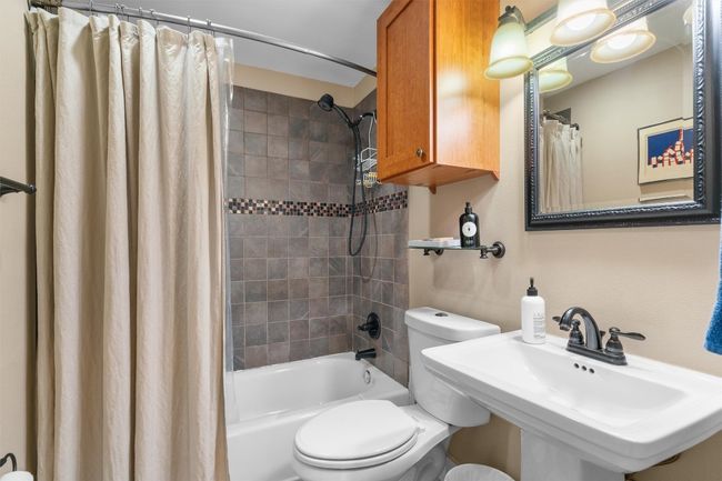 Bathroom with shower / bath combo with shower curtain, a sink, and toilet | Image 20