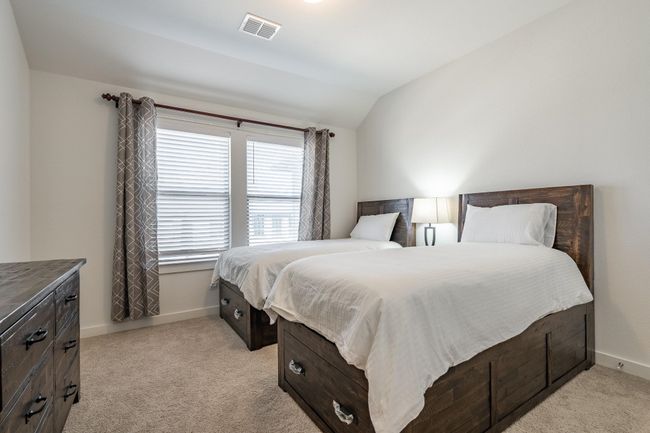 Bedroom featuring light carpet, visible vents, baseboards, and vaulted ceiling | Image 17