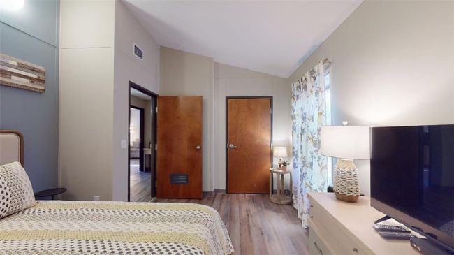 Bedroom featuring wood finished floors and lofted ceiling | Image 30