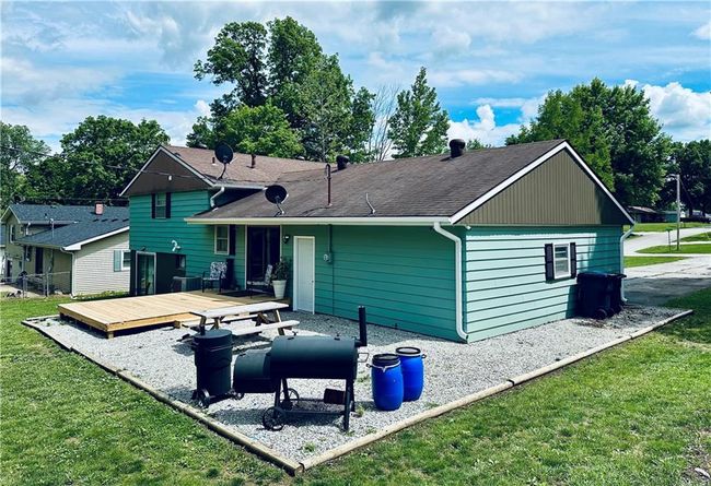 Rear view of property featuring a wooden deck, a lawn, and a shingled roof | Image 26