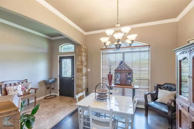 Dining room with a chandelier, arched walkways, ornamental molding, and baseboards | Image 5