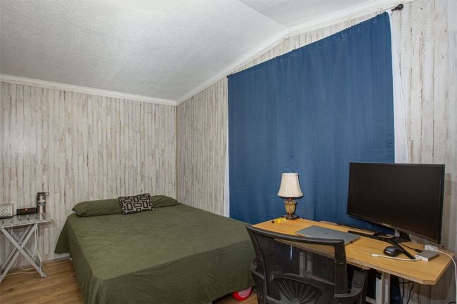 Bedroom featuring a textured ceiling, crown molding, hardwood / wood-style floors, and vaulted ceiling | Image 13