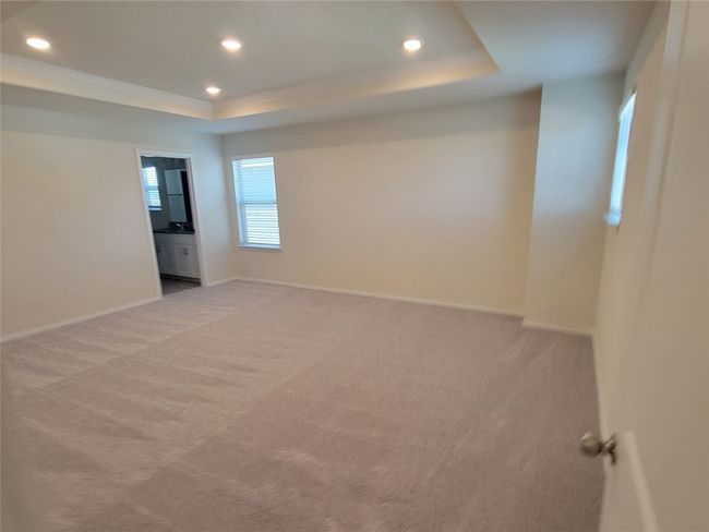 Empty room with light colored carpet, recessed lighting, and a raised ceiling | Image 18