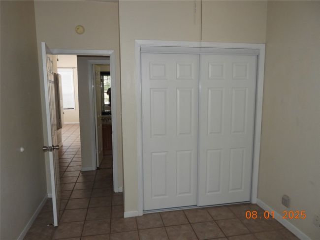 Unfurnished bedroom featuring dark tile patterned flooring and a closet | Image 14