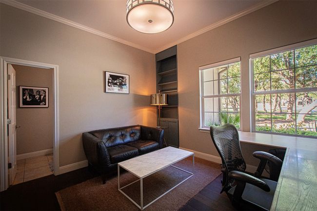 Office with healthy amount of natural light, built in shelves, baseboards, crown molding, and wood finished floors | Image 25