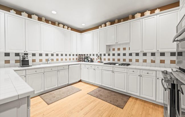 Kitchen with tile countertops, wall oven, tasteful backsplash, white cabinetry, and recessed lighting | Image 14
