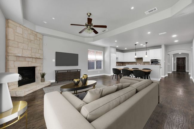 Living area featuring a ceiling fan, arched walkways, a fireplace, recessed lighting, and dark wood-style flooring | Image 9