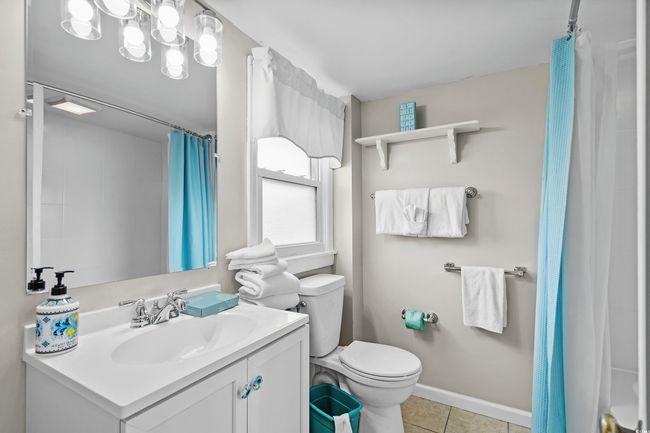 Full bathroom featuring vanity, toilet, tile patterned flooring, and curtained shower | Image 27
