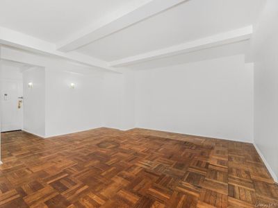 Empty room with beam ceiling and dark parquet flooring | Image 3