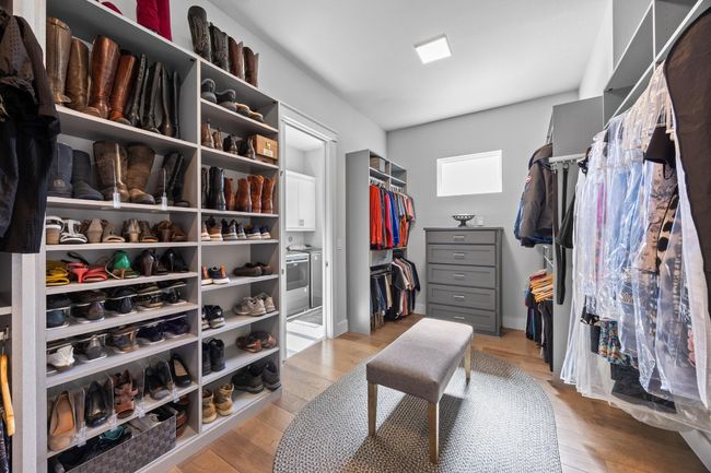 The expansive walk-in closet features a custom-built system along with wardrobe organizers for ultimate convenience. | Image 25