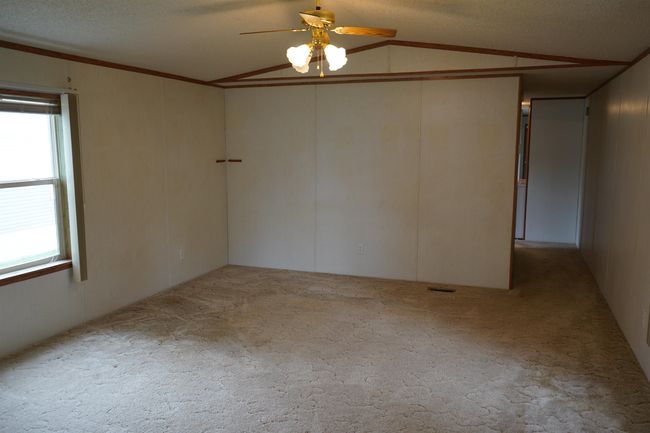 Empty room featuring lofted ceiling, a ceiling fan, and carpet flooring | Image 14