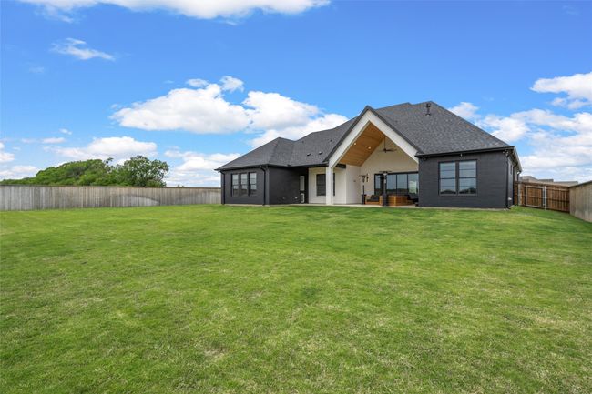 Rear view of house with roof with shingles, a yard, ceiling fan, and a fenced backyard | Image 39