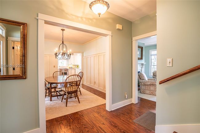 Dining room with hardwood / wood-style floors, a notable chandelier, and crown molding | Image 9