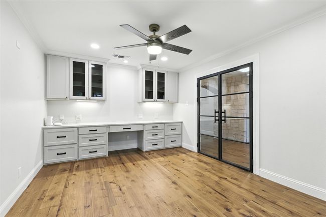 Unfurnished office featuring built in desk, ceiling fan, crown molding, light wood finished floors, and recessed lighting | Image 19