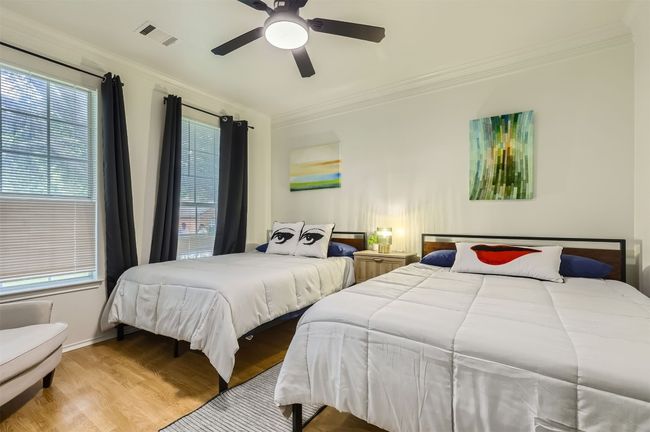 Bedroom with wood finished floors, crown molding, multiple windows, and ceiling fan | Image 12