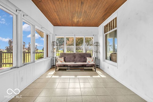 sunroom / solarium featuring wooden ceiling, tile patterned floors, and plenty of natural light | Image 12