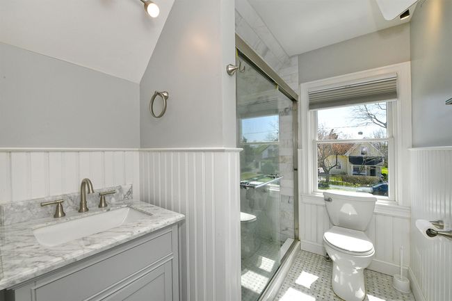 Full bathroom with vanity, toilet, a stall shower, and a wainscoted wall | Image 32