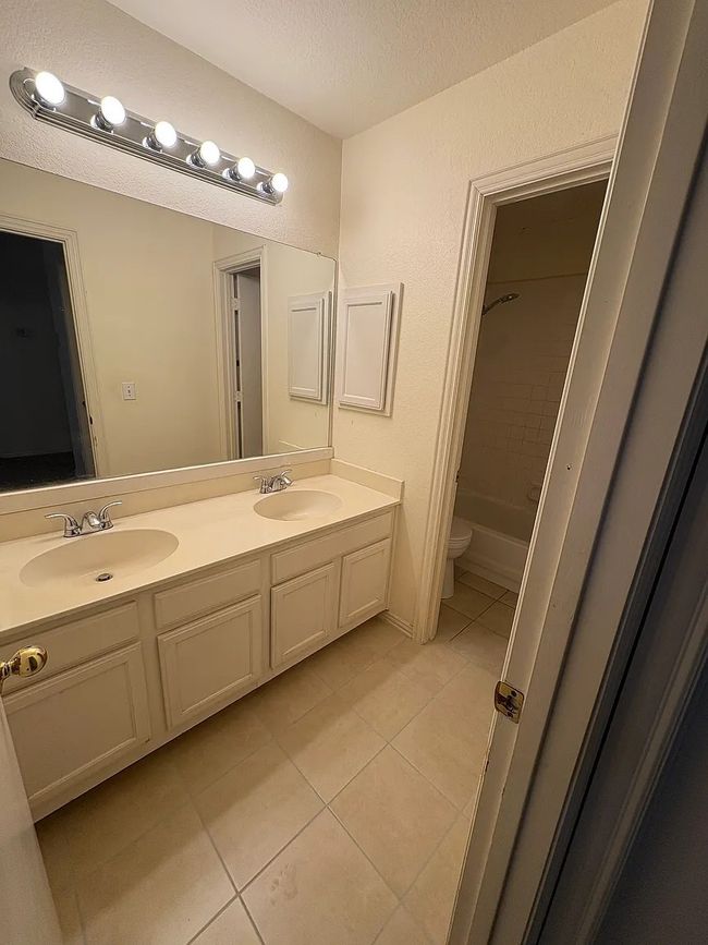 Full bath with tile patterned floors, double vanity, and a textured ceiling | Image 11