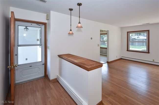 Doorway featuring baseboards, baseboard heating, wood finished floors, and a baseboard radiator | Image 40