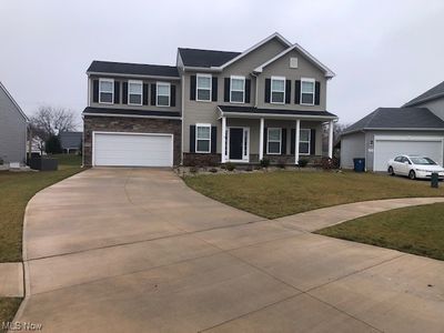 View of front facade with a garage and a front yard | Image 1