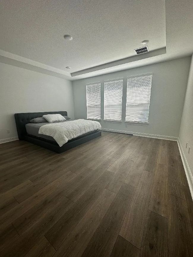 Bedroom with a textured ceiling and dark wood-style flooring | Image 6