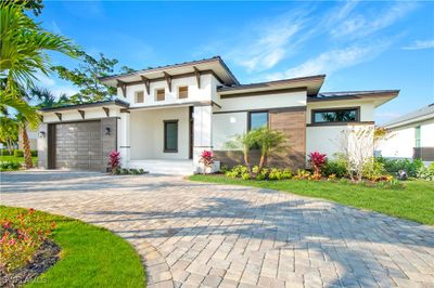 View of front facade featuring a front yard and a garage | Image 1