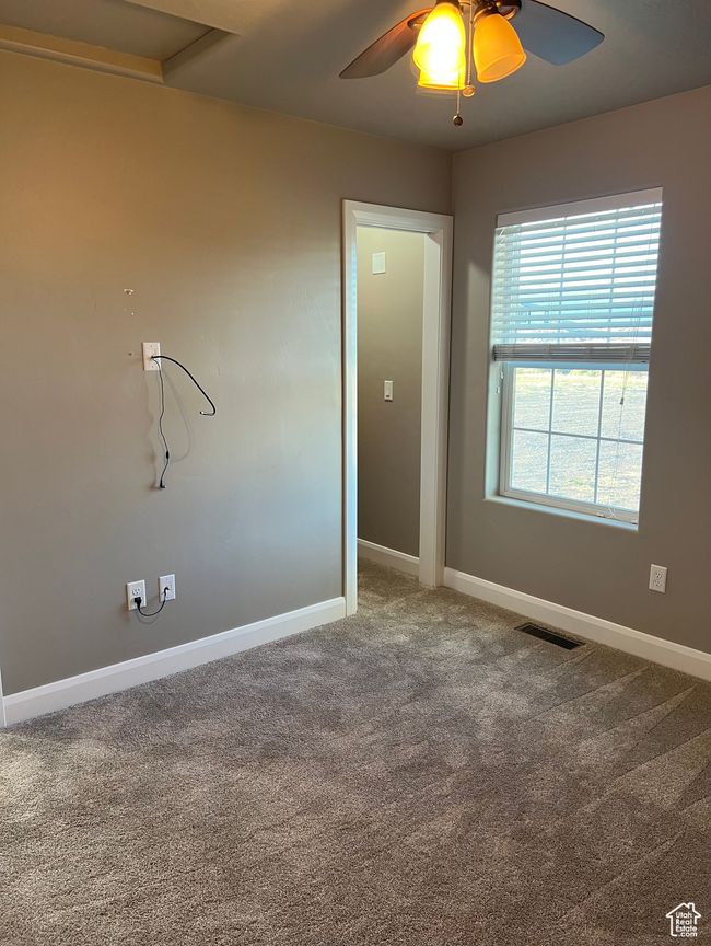 Carpeted empty room featuring baseboards and ceiling fan | Image 42