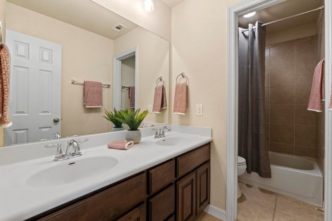 Full bath featuring double vanity, shower / bath combination with curtain, and tile patterned flooring | Image 32
