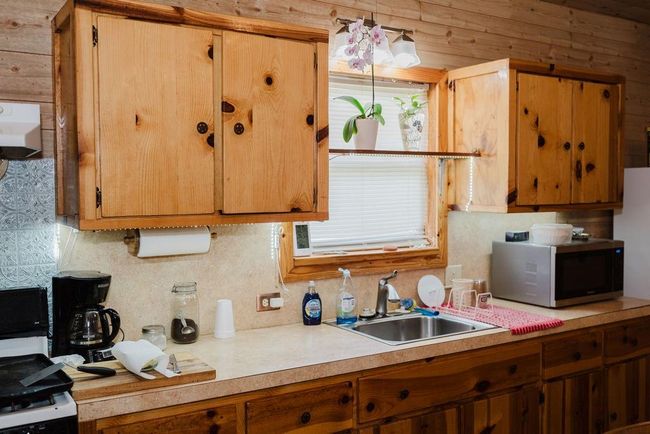 Kitchen featuring stainless steel microwave, light countertops, and wood cabinetry | Image 10