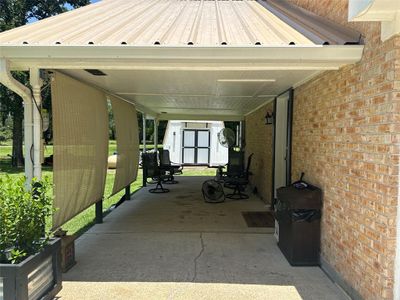 View of the carport space with another entrance into the converted garage. | Image 3