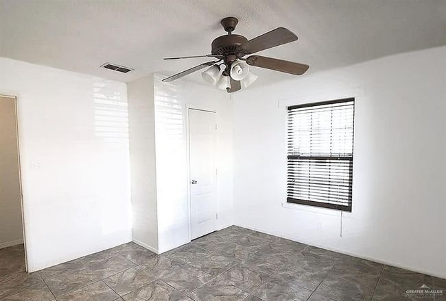 Spare room featuring ceiling fan and stone finish flooring | Image 5